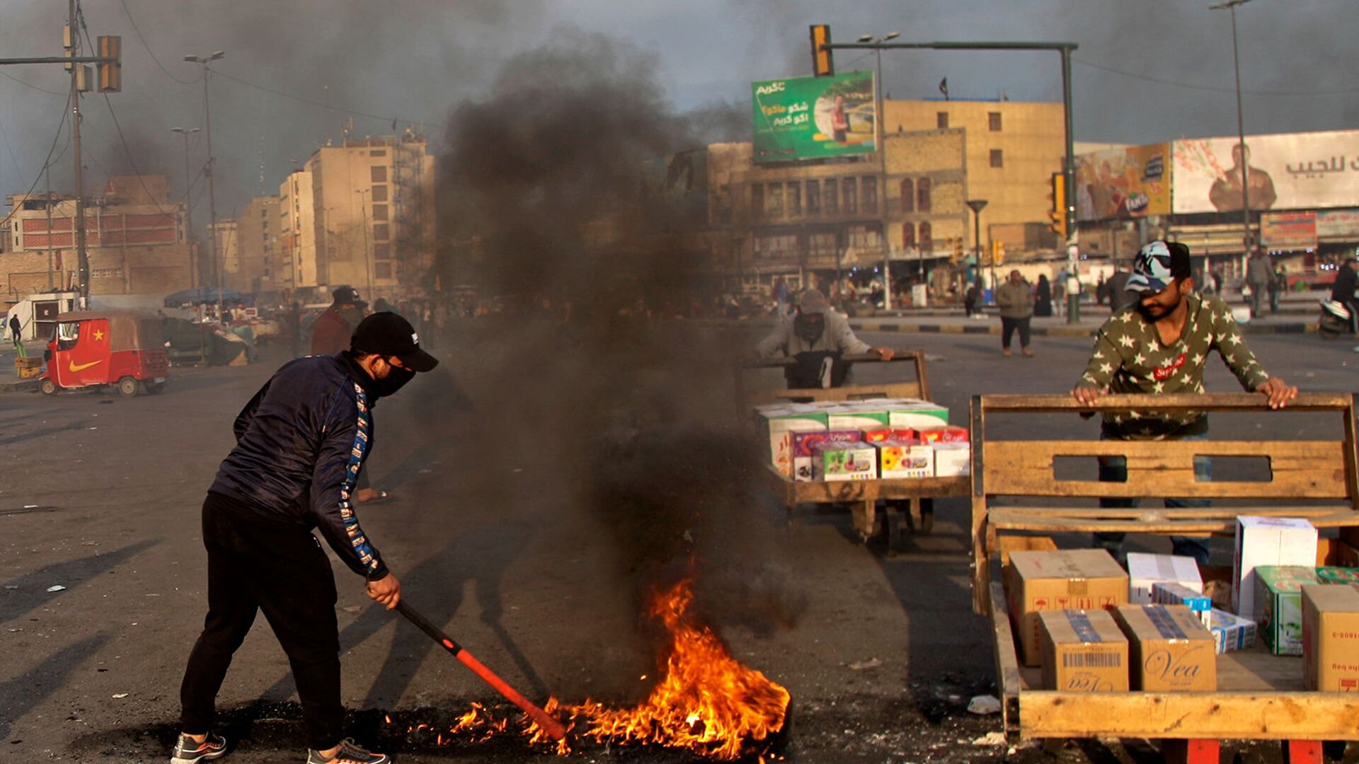 Протестующие устроили поджоги, чтобы закрыть улицы возле площади Тахрир во время демонстрации протеста против иранского ракетного удара (8 января 2020). Багдад - Sputnik Армения, 1920, 22.07.2021