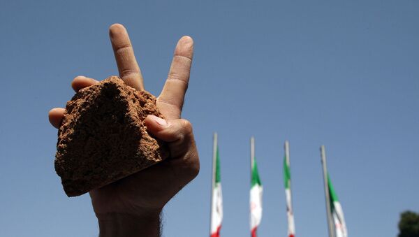 Иранский студент с камнем в руке во время парада, посвященного Дню Аль-Кудса (26 сентября 2008). Тегеран - Sputnik Արմենիա