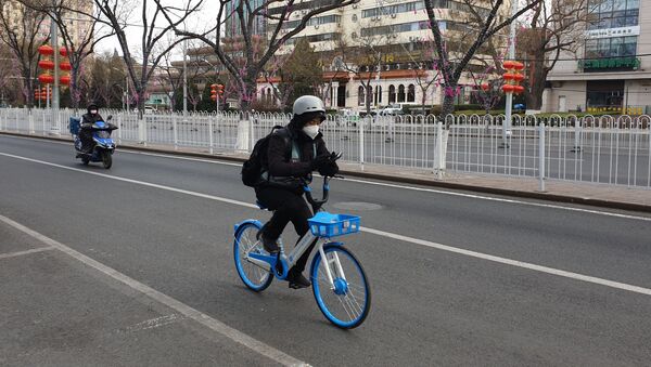 Жители Пекина в медицинских масках едут по улице города - Sputnik Армения