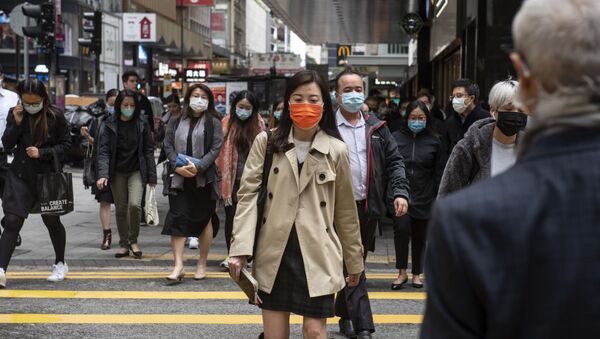Прохожие в защитных масках на одной из улиц в Гонконге. - Sputnik Армения