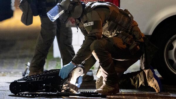 Офицер спецназа работает над роботом перед домом, который обыскивает полиция в Ханау после стрельбы в кальянной, где были убиты 8 человек (19 февраля 2020). Германия - Sputnik Армения