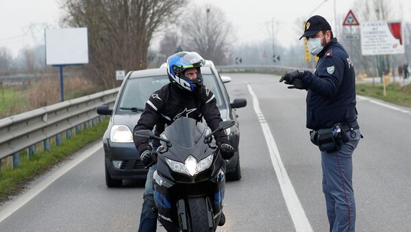 Полицейские в масках предупреждают водителей на дороге между Кодоньо и Казальпустерленго, которая была закрыта из-за вспышки коронавируса в северной Италии - Sputnik Армения