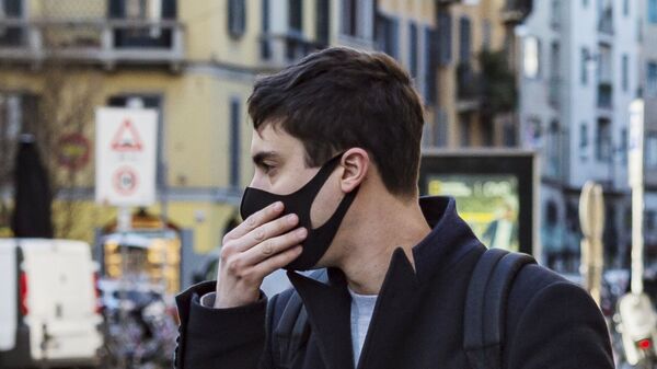 Мужчина в защитной маске на одной из улиц Милана - Sputnik Армения