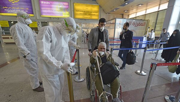 Медицинский персонал измеряет температуру пассажиров, возвращающихся из Ирана в международном аэропорту Наджаф (5 марта 2020). Ирак - Sputnik Армения