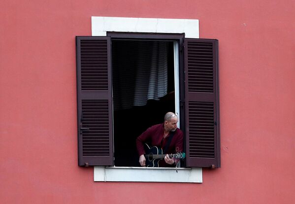 Տղամարդը կիթառ է նվագում իր բնակարանի լուսամուտից, 2020 թվականի մարտի 13, Հռոմ - Sputnik Արմենիա