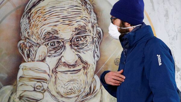 Мужчина в защитной маске проходит мимо фрески папы Франциска (13 марта 2020). Рим - Sputnik Армения