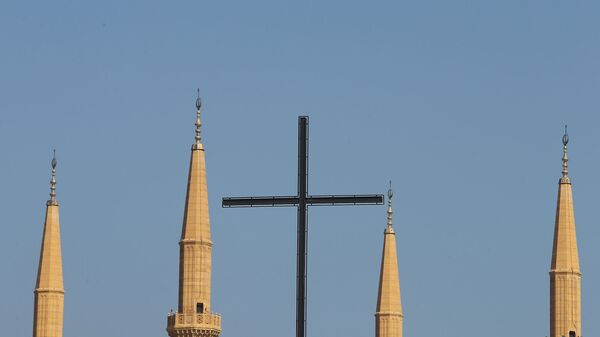 Крест бейрутской Церкви Лазарита на фоне минаретов мечети Мухаммеда аль-Амина в центре ливанской столицы (9 октября 2014). Бейрут - Sputnik Армения