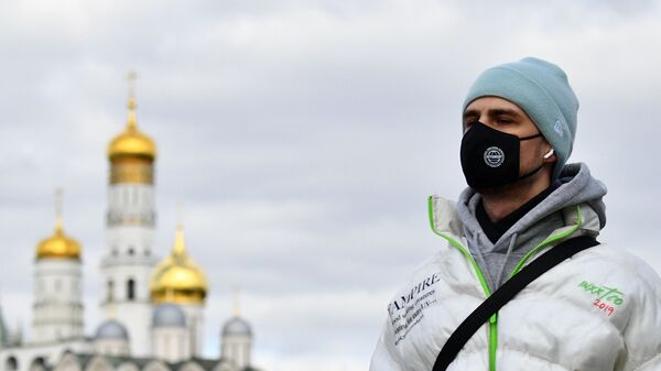 Молодой человек в защитной маске в Москве - Sputnik Армения