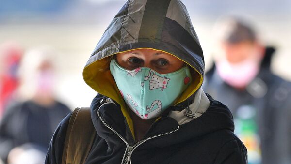 Пассажир в защитной медицинской маске в минском аэропорту в связи с коронавирусом - Sputnik Армения