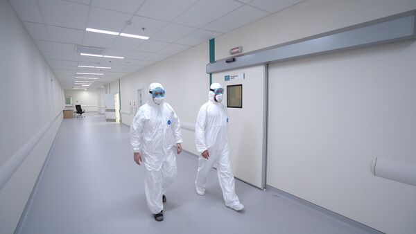 Врачи в защитных костюмах в больнице для приема пациентов с подозрением на коронавирус - Sputnik Армения