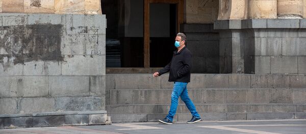 Прохожий в защитной маске на площади Республики (26 марта 2020). Ереван - Sputnik Армения