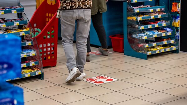 Разметки для соблюдения дистанции на полу в супермаркете Carrefour (27 марта 2020). Еревaн - Sputnik Армения