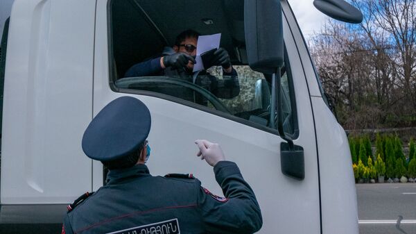 Полицейский проверяет документы у водителей и пассажиров автомобилей, выезжающего из столицы (2 апреля 2020). Еревaн - Sputnik Արմենիա