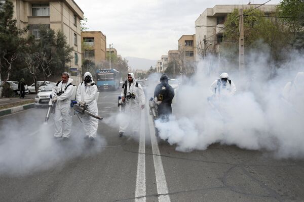 Пожарные в защитных масках дезинфицируют улицы в преддверии иранского Нового года Навруз (20 марта 2020). Тегеран - Sputnik Армения