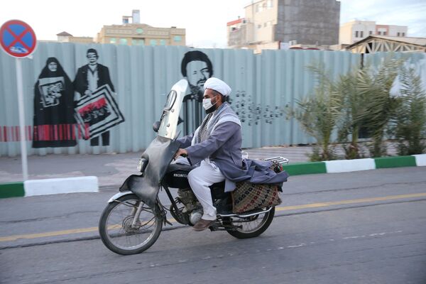 Священнослужитель в защитной маске едет на своем мотоцикле в город Кум (24 марта 2020). Иран - Sputnik Армения