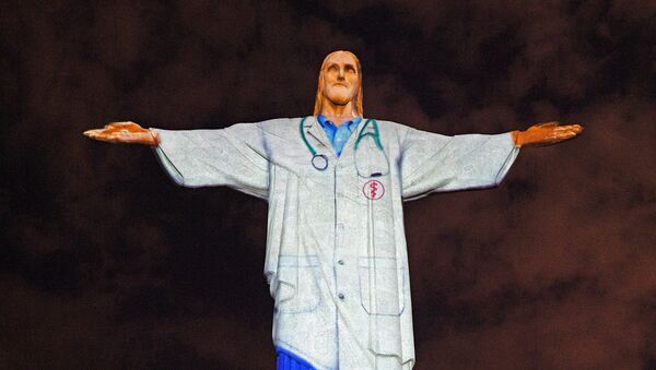 Статуя Христа-Искупителя в день Пасхи с проецируемой на ней униформой врача в честь всего медицинского персонала, борющегося с пандемией коронавируса COVID-9 (12 апреля 2020). Рио-де-Жанейро - Sputnik Армения