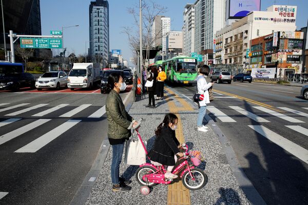 Мама с ребенком в медицинских масках на пешеходном переходе в Сеуле, Южная Корея - Sputnik Армения