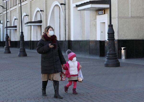 Женщина с ребенком в защитных масках на железнодорожном вокзале в Киеве, Украина - Sputnik Армения