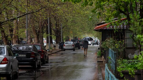 Молодой человек с зонтом на улице Арами - Sputnik Армения