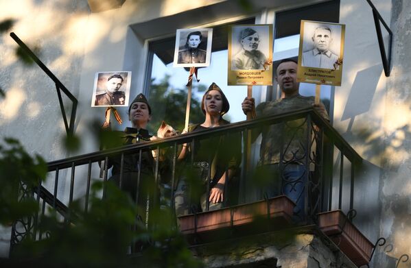 Համառուսաստանյան ակցիայի շրջանակում պատերազմ անցած բարեկամների լուսանկարները ձեռքներին պատշգամբում կանգնած տան բնակիչները երգում են (2020 թվականի մայիսի 9), Սևաստոպոլ

 - Sputnik Արմենիա