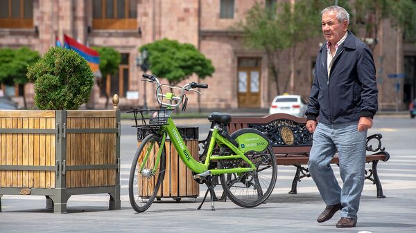 Мужчина проходит мимо велосипеда на площади Республики - Sputnik Արմենիա