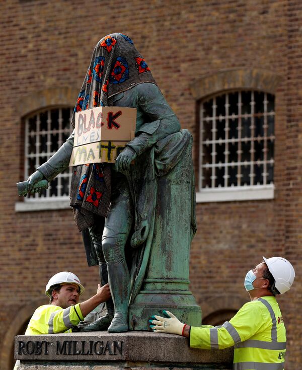  Рабочие убирают статую Роберта Миллигана, накрытую одеялом и с надписью Black Lives Matter», Лондон, Великобритания - Sputnik Армения