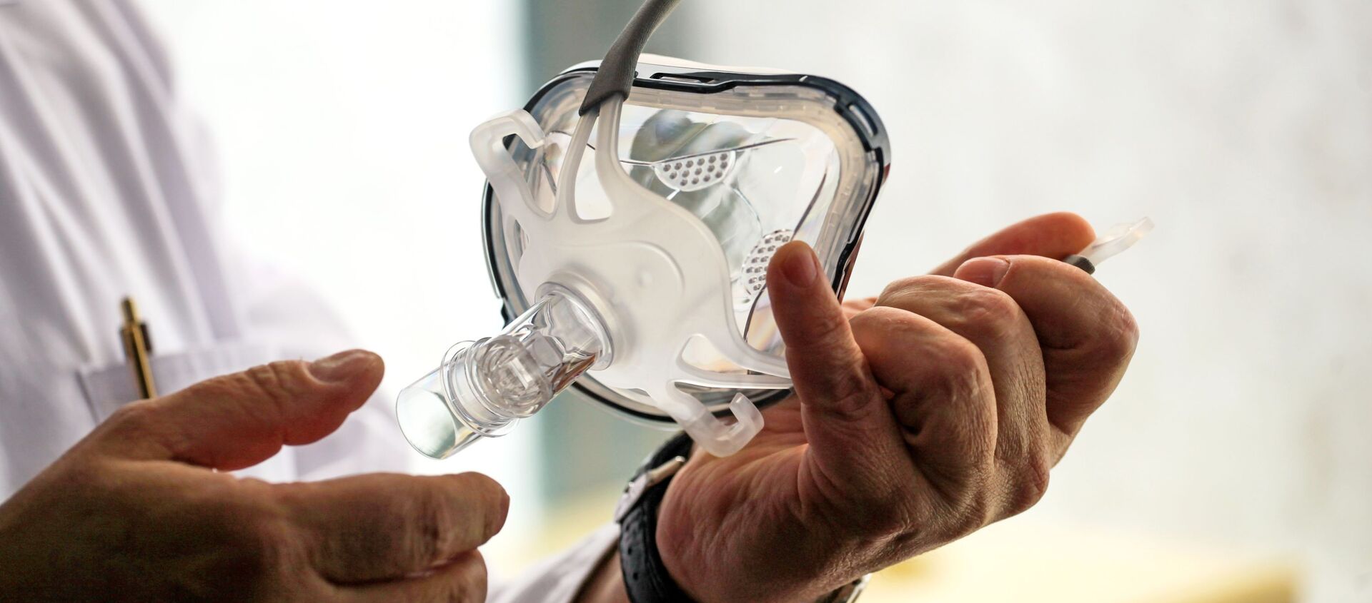 Врач держит в руках маску для искусственной вентиляции легких в палате госпиталя ветеранов войн в Иркутске - Sputnik Армения, 1920, 23.03.2021