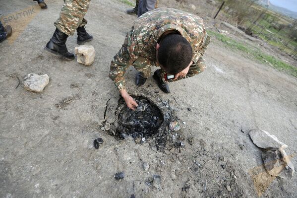Военнослужащие рассматривают следы, оставленные снарядами системы Смерч. - Sputnik Армения