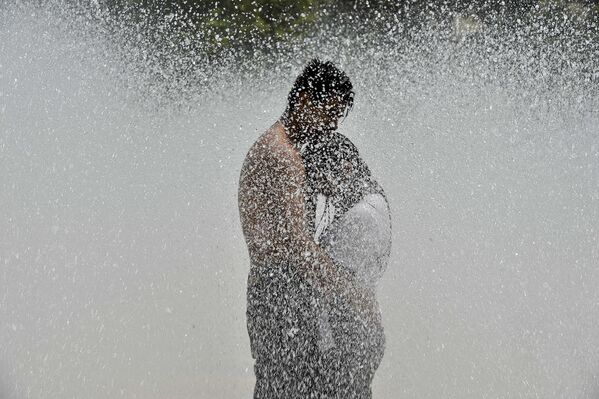 Пара решила спастись от жары в фонтане на площади Революции в Мехико - Sputnik Армения