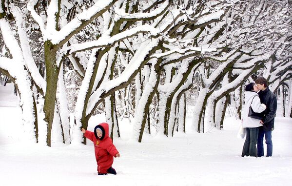 Малыш радуется снегу, пока мама с папой целуются в парке - Sputnik Армения