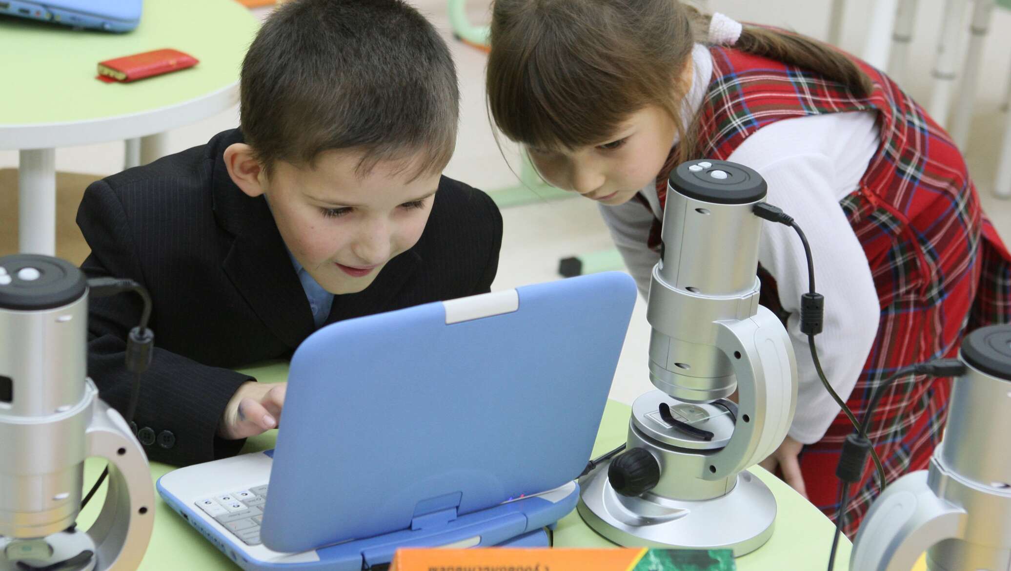 Изучение биологии в школе. Цифровой микроскоп в начальной школе. Ребенок у микроскопа в школе. Исследование школьников. Школьник исследователь.