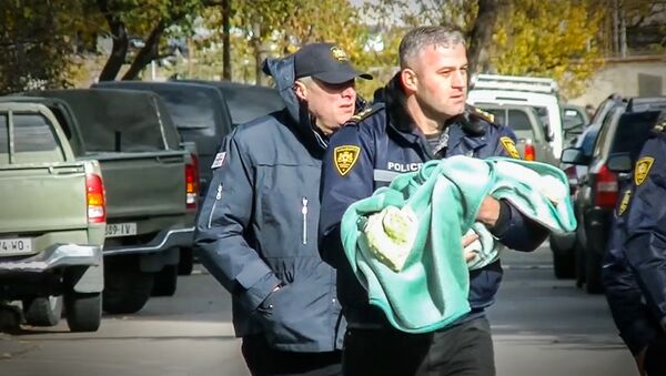 Спецназовец выносит ребенка из зоны спецоперации в Тбилиси - Sputnik Արմենիա