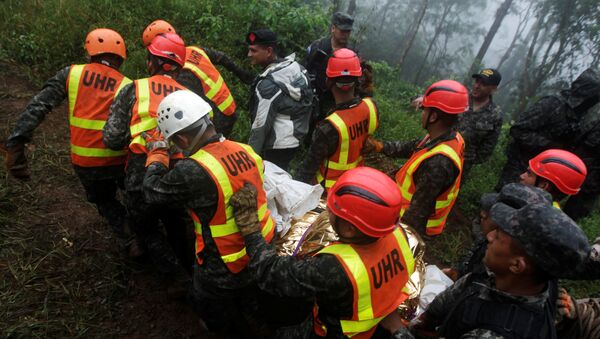 Спасатели выносят тело, найденное в районе крушения вертолета. Сан-Матиас, Гондурас - Sputnik Армения